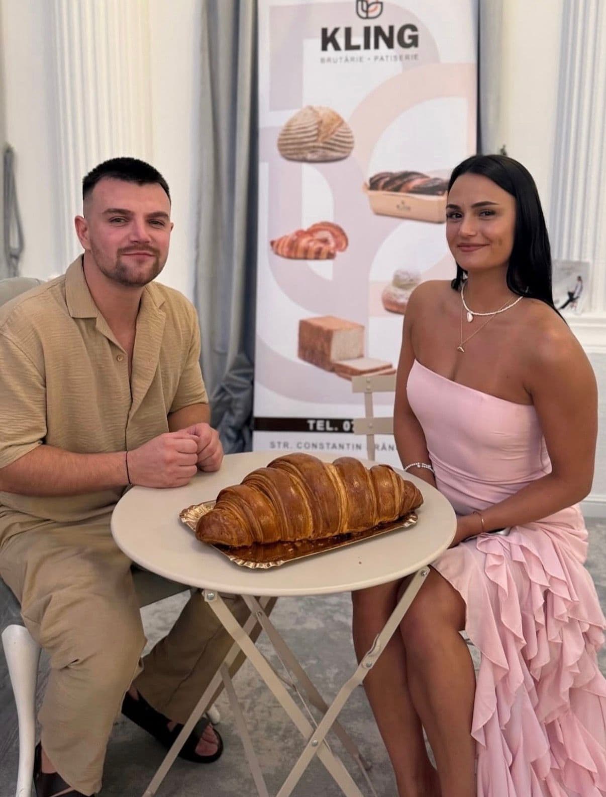 Cei doi frați Kling, la o masă de bistro, cu croissantul gigant pe platou